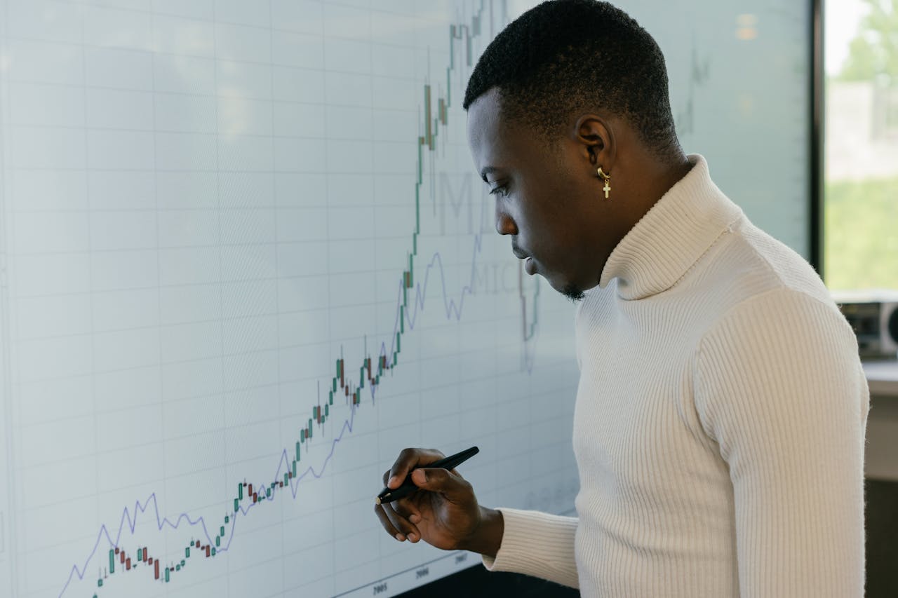 Young male strategist analyzing financial growth trends on a digital screen.